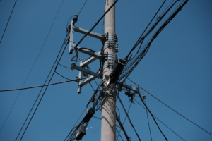Electric pole with wires against a blue sky.