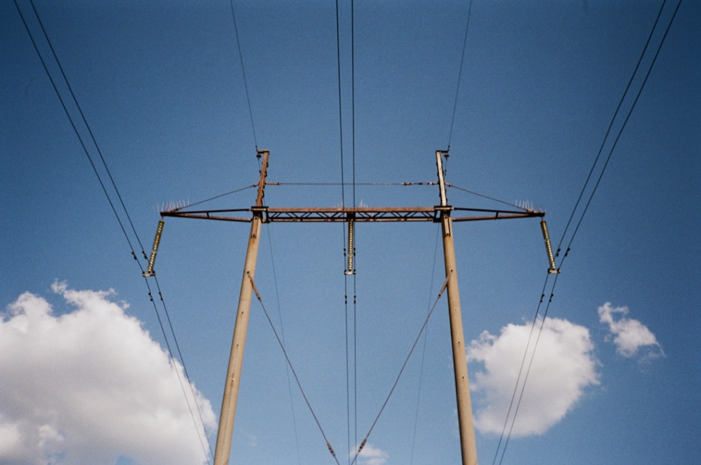 Power lines stretch across a bright, blue sky.