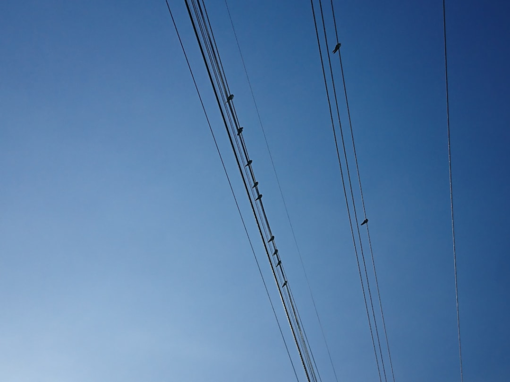 a group of power lines against a blue sky