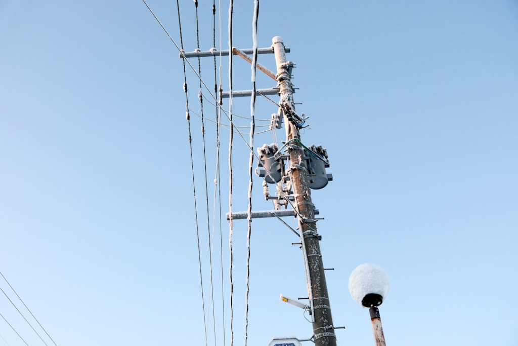 A telephone pole with a bunch of wires attached to it